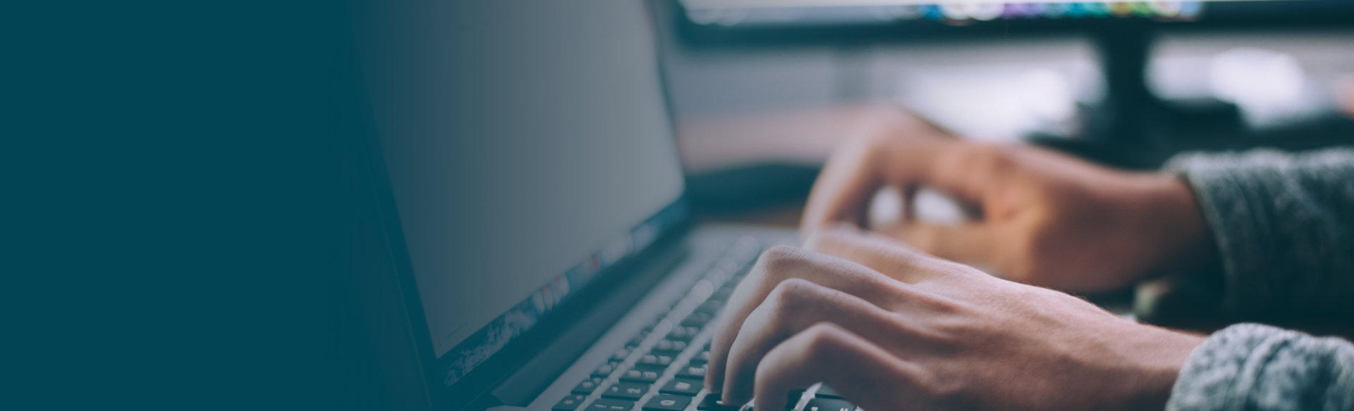 Human hands zoomed in typing on a laptops keyboard